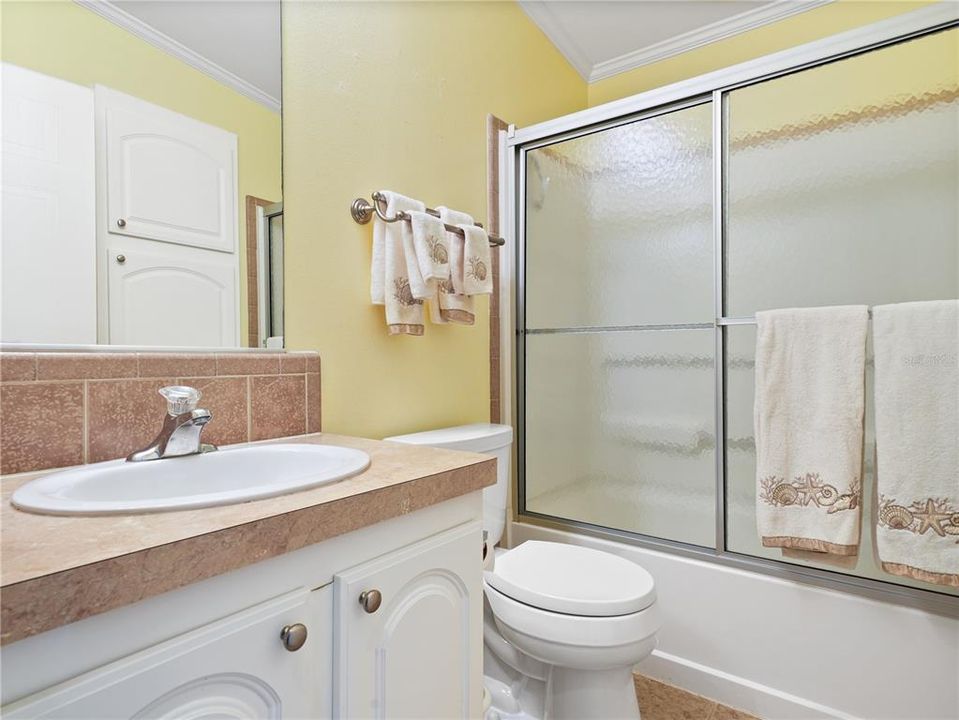 The guest bathroom has a tub and shower.