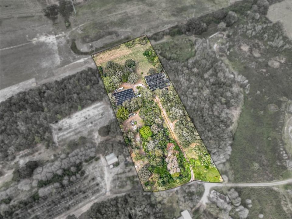 Aerial view of property.  The building to the right is the first greenhouse.  Neighbor's pasture can be viewed at the rear of the property.