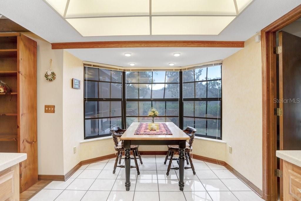The dinette area in the kitchen features a beautiful bay window that looks out to the backyard and pool.