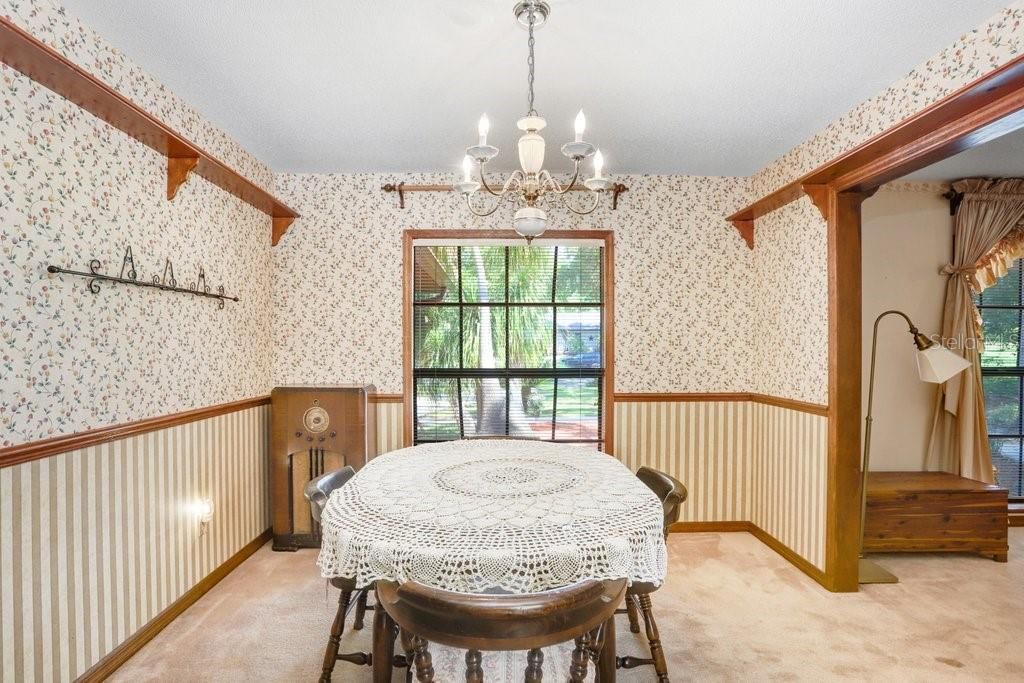 The dining room is spacious and has a large window that looks out to the front yard of the home.