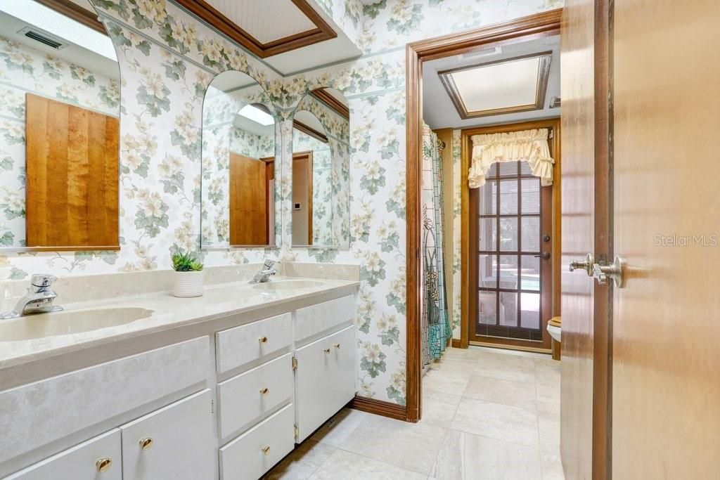The guest bathroom features dual sinks, tub/shower combo, a linen closet, and doubles as a pool bath!