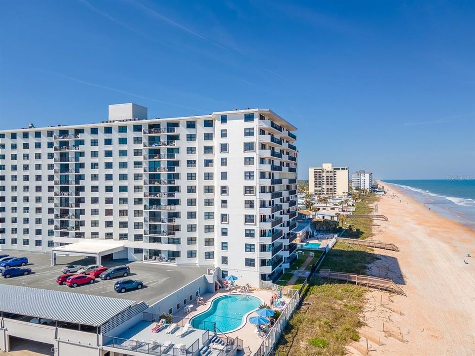 Condo outdoor amenities include a gated dune walk-over, beachside pool and elevated lounging deck plus a grilling area with seating.