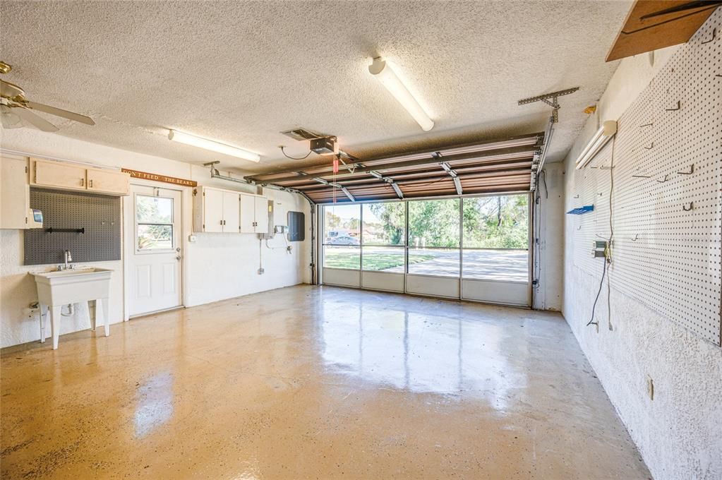 Garage features, Automatic Door Opener, Screen Door, Laundry area with Utility Sink, wall storage, Sprinkler Panel, and Pegboard for organizing your tools.