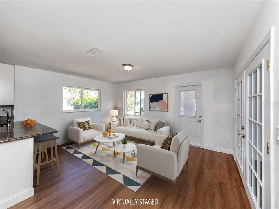 Virtually Staged Photo. The family room is just spacious enough and the breakfast bar extends the kitchen to the area.