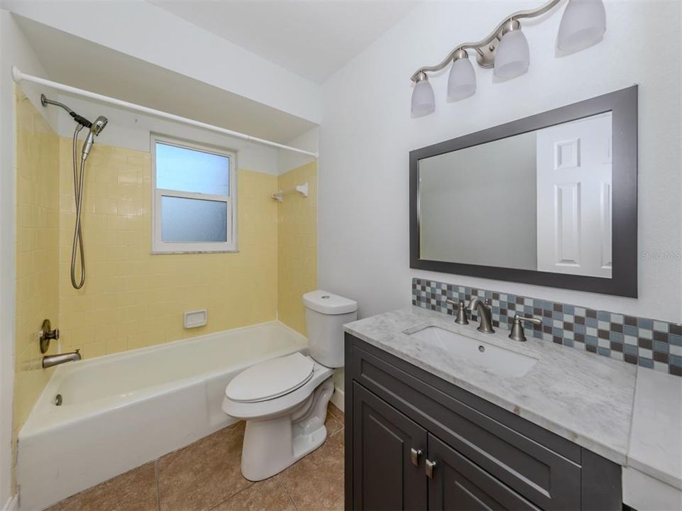 The guest bathroom is adorable with the retro yellow tile!