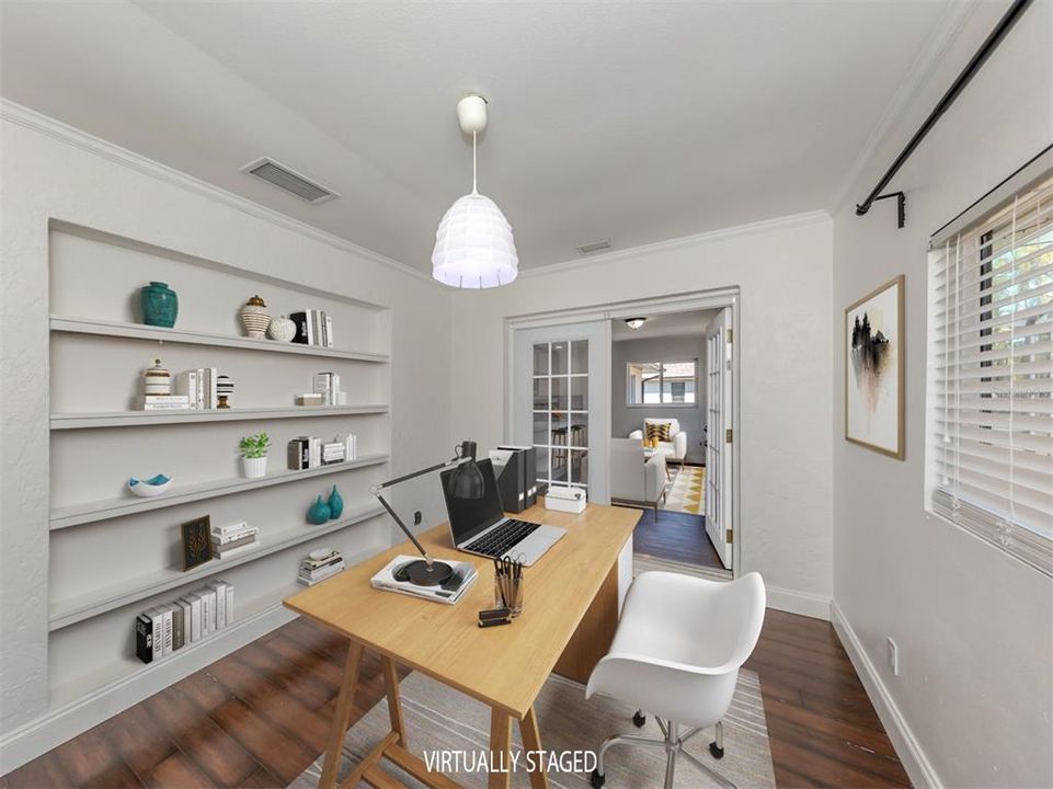 What a cute space with French doors, built in shelving and a window to the back yard!