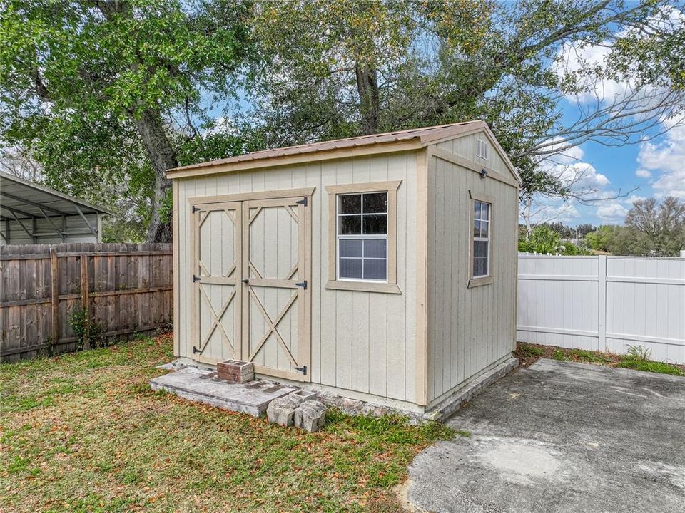 Storage shed with metal roof will remain.  Concrete pad would be great for barbeques.