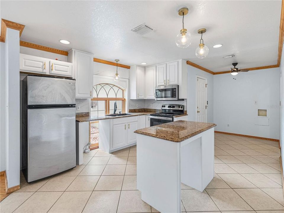 Kitchen with beautiful view of the front yard from the large window.  Door in the picture leads to the garage.