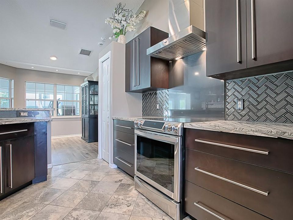 Kitchen offers travertine flooring, and the Chef Collection Induction Range and Convection oven.