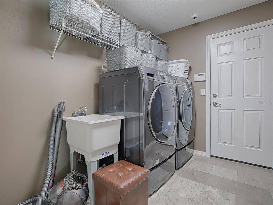 Laundry room with washer & dryer, and marble floors.