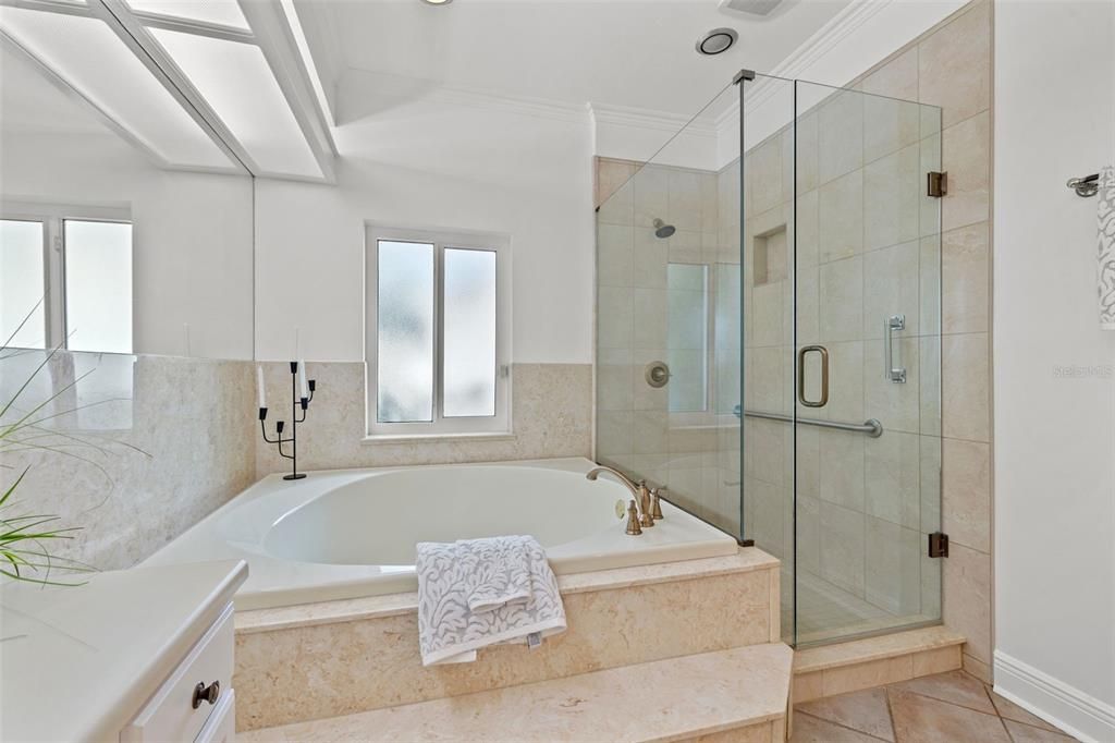 Master bathroom with built in tub and glass enclosure shower