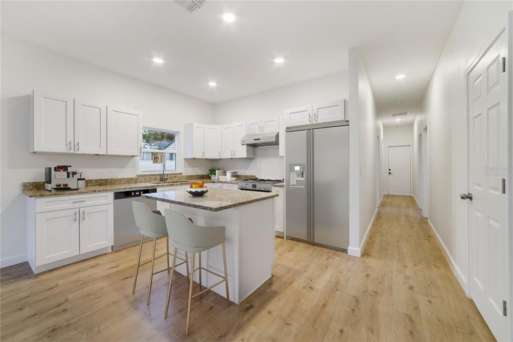 A light and bright OPEN CONCEPT delivers a spacious kitchen featuring desirable shaker style cabinetry, ISLAND with breakfast bar seating, GRANITE COUNTERS and pantry for ample storage. Virtually Staged/Appliances Virtually Staged.