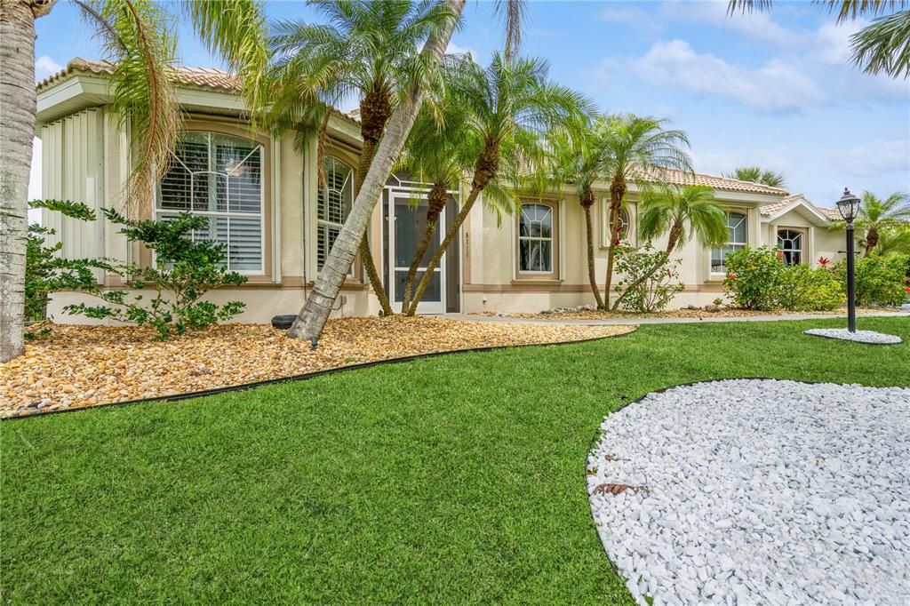 Front of home with beautiful palm trees