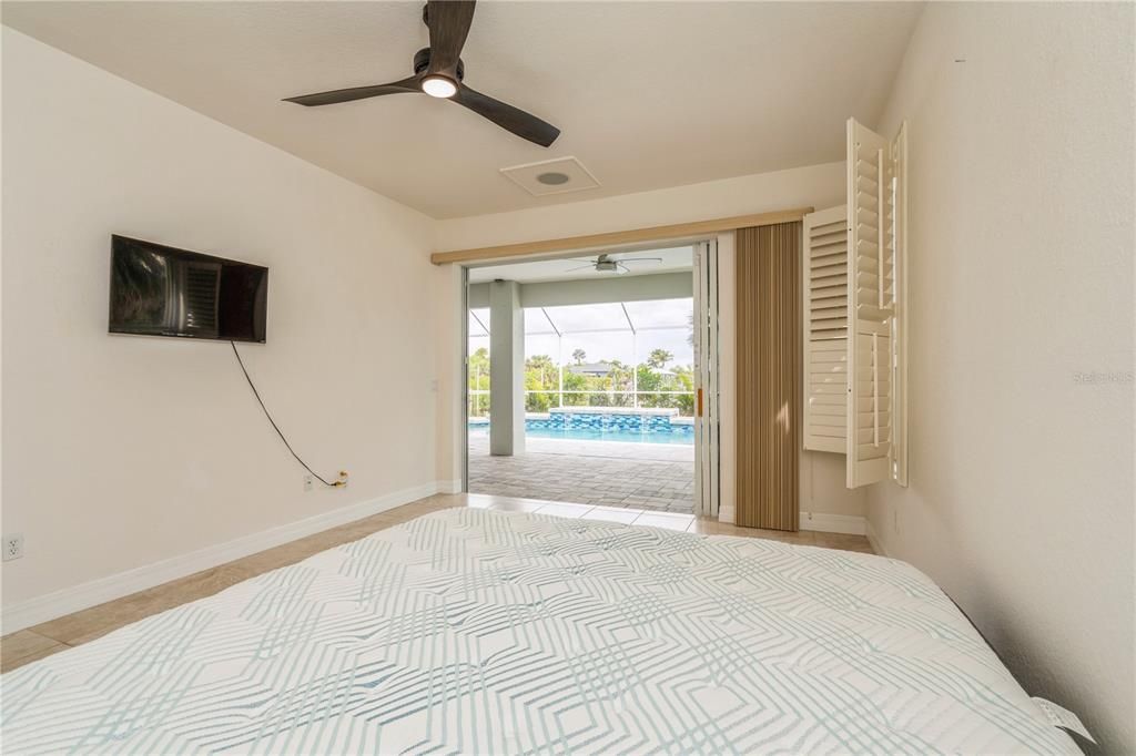 Master bedroom with glass slider an a view of the pool