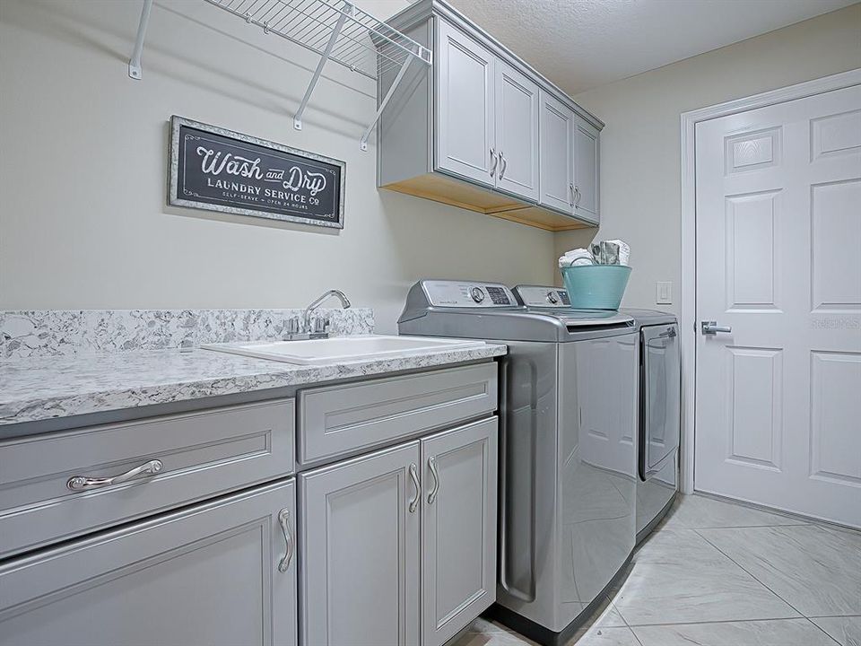 Laundry room also has EXTRA cabinetry and wall mounted hanging / drying rack and Quartz countertops