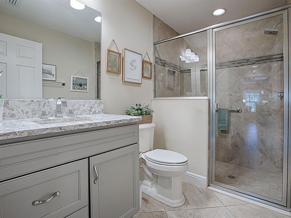 Bath #3 has a step in tiled shower with bench seat and glass enclosure, as well as Quartz countertops