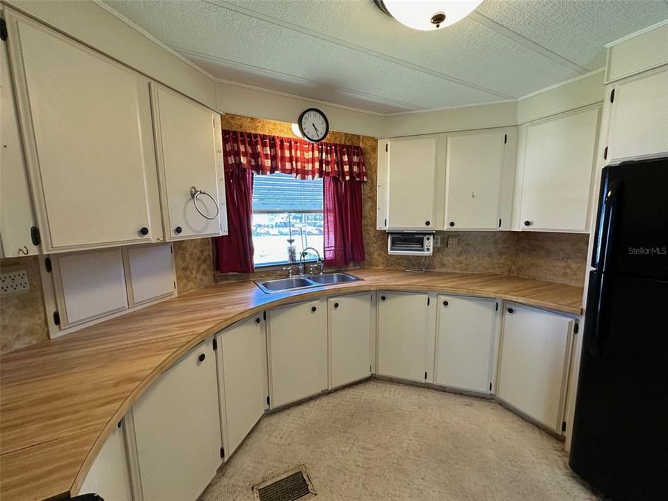 U-shaped kitchen with window looking into front yard