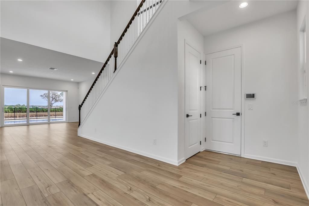 Entry with storage under staircase. Garage access on the right