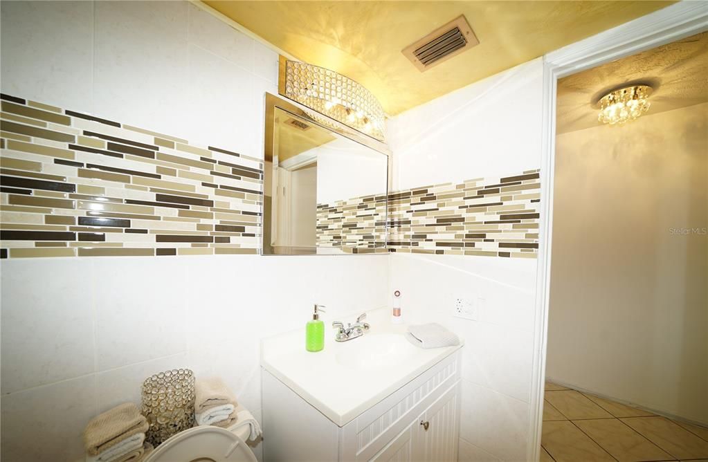 ELEGANT BATHROOM VANITY AND LIGHTS VISIBLE