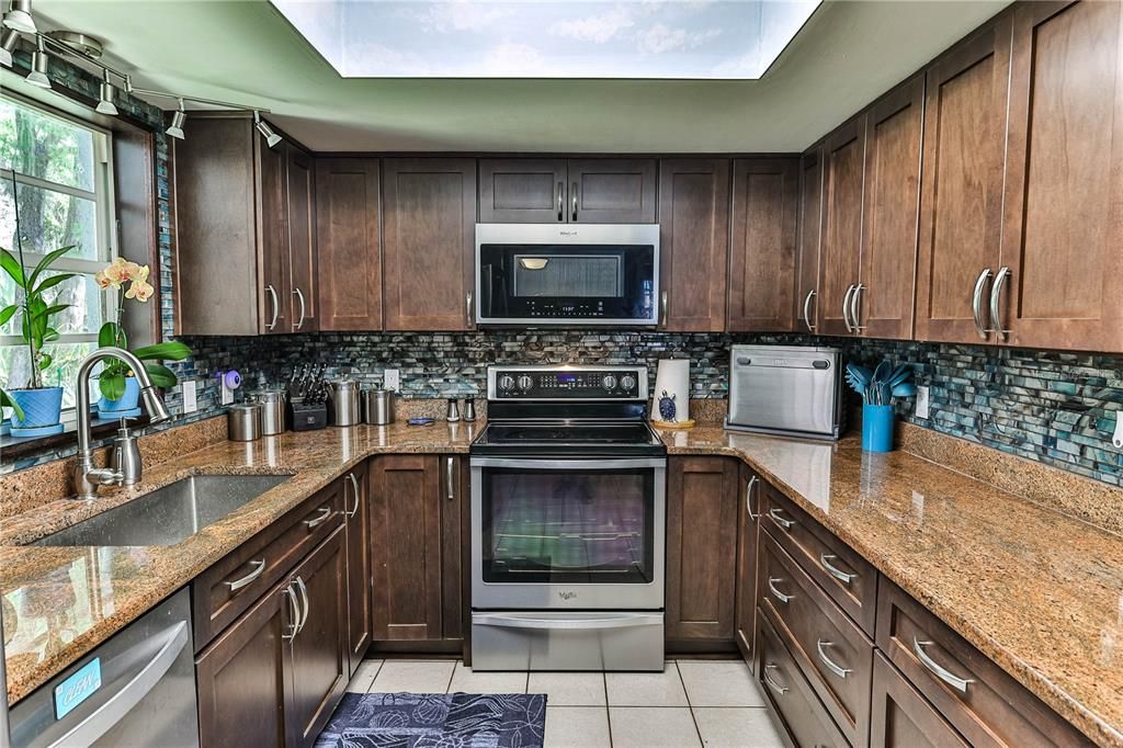 Recently updated kitchen with Wood Cabinetry, granite counter tops, soft close drawers,  SS appliances, decorative backsplash & lighting