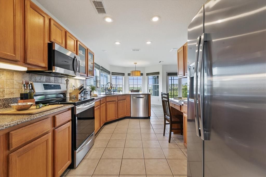 Spacious kitchen with wood cabinetry and granite counters