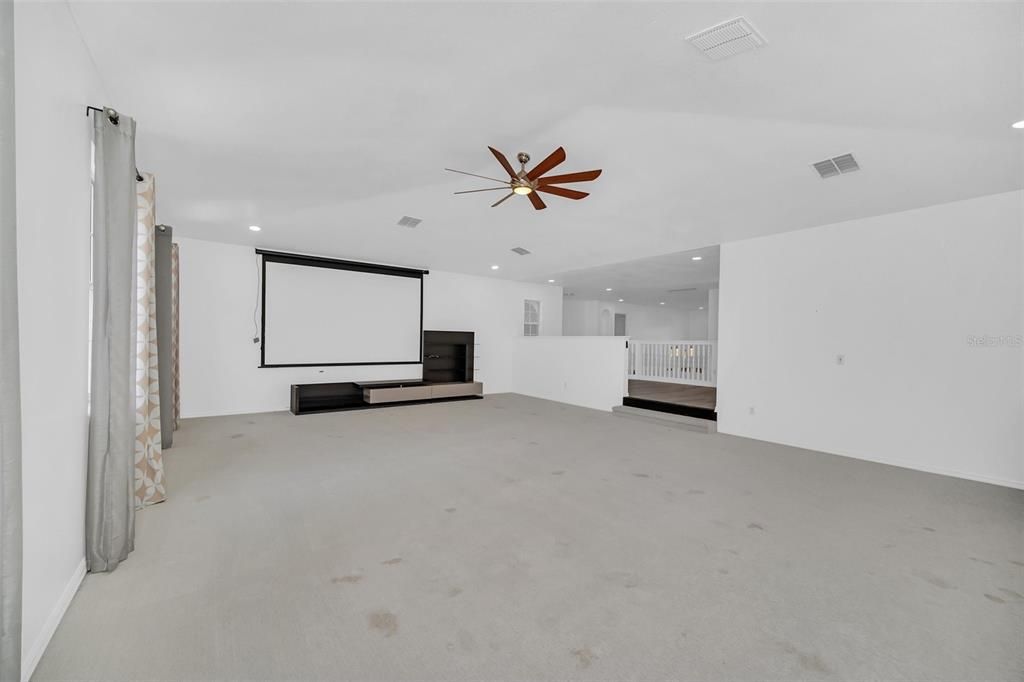 Media room with loft in background