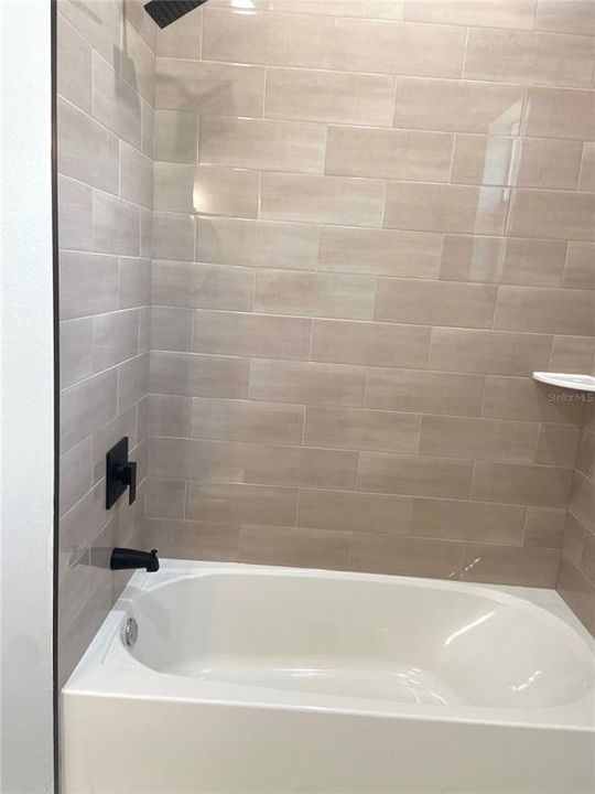 hall bath with tiled tub/shower combo