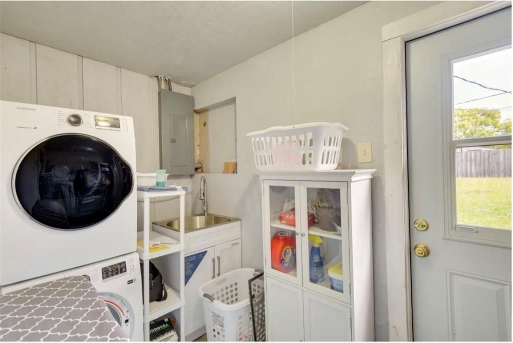 Utility room w/sink, washer/dryer & lots of shelving.