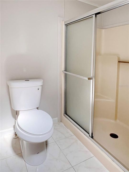 Primary Bath featuring a New Comfort Height Toilet and a Walk-in Shower
