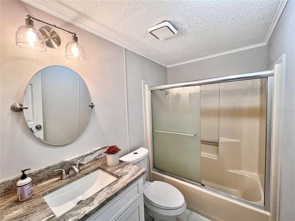 Guest Bathroom featuring new White Shaker Vanity, Granite Countertop, Comfort Height Toilet, Mirror, Lighting and paint