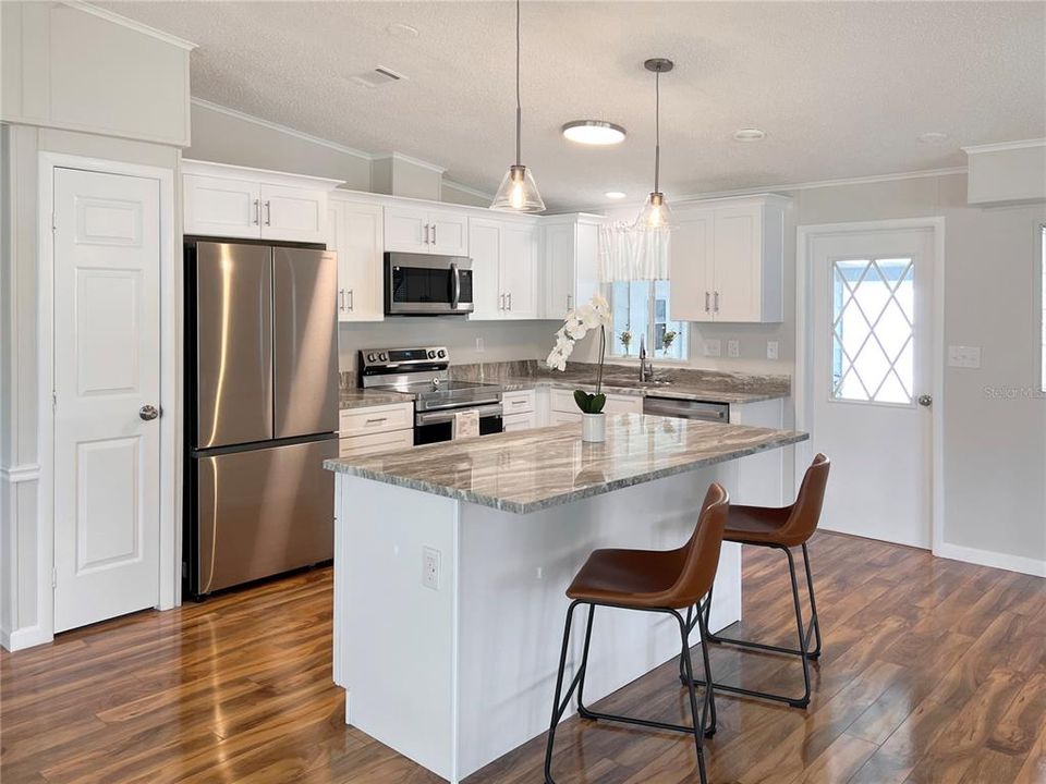 Newly renovated Kitchen featuring White Shaker Cabinets, Granite Countertops and Stainless Steel Appliances.