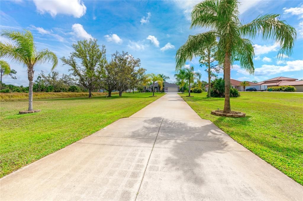 Set back from the road on 1.11 acres with Palm lined driveway