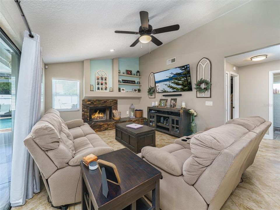 The family room is off of the kitchen and has a beautiful stone wood burning  fireplace.