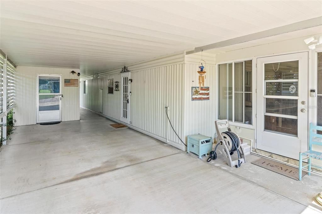 CARPORT WITH VIEW OF UTILITY ROOM ON LEFT AND ENTRANCE TO FLORIDA ROOM