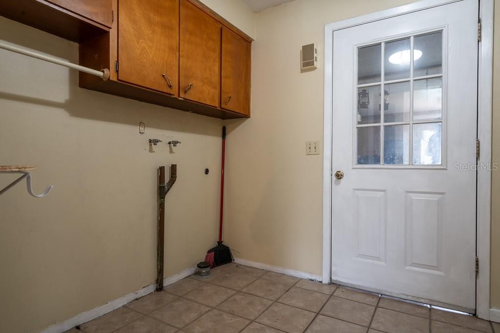 Indoor Laundry with storage shelves and cabinets