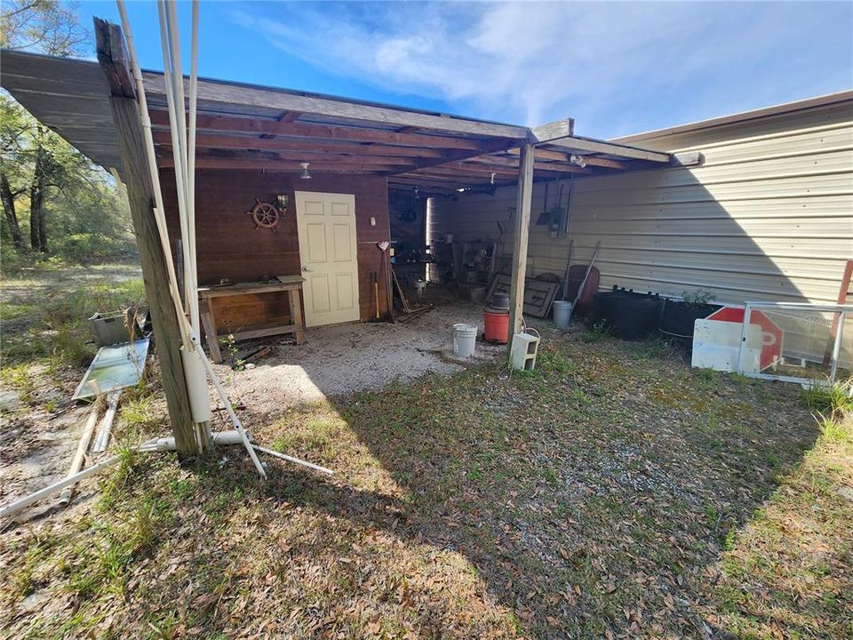 Lean-to behind metal storage building.