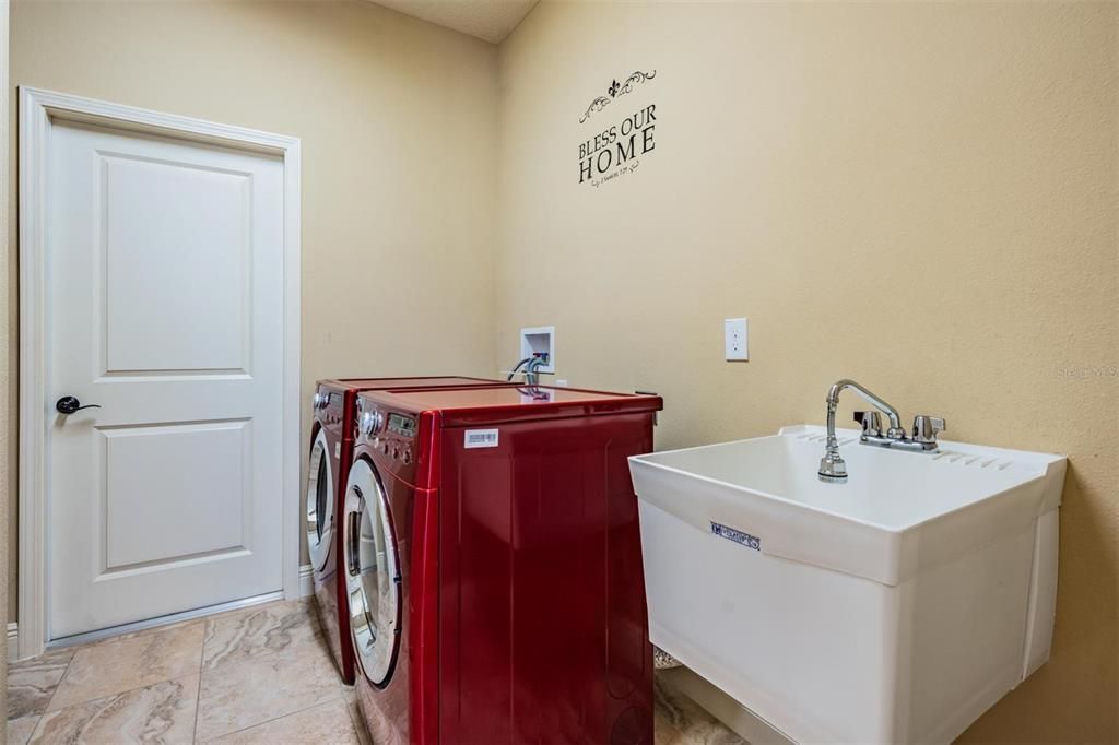 Laundry room off garage with utility sink