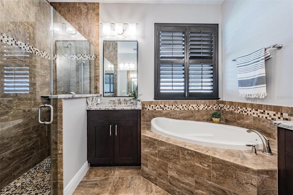 Thoughtful bathroom layout with a corner tub and double, split vanities