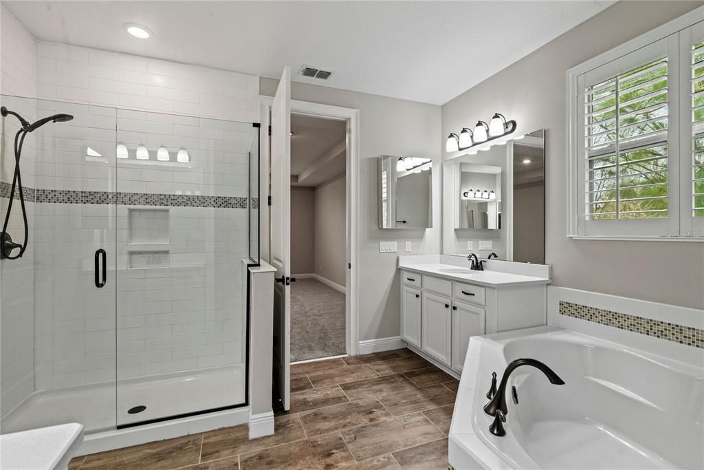 Spacious master bath with double granite vanities, soaker tub and glass enclosed tiled shower