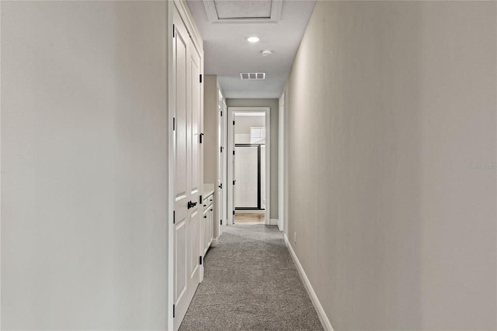 Private hallway with walk in storage closet and drop zone lead to Bedroom 4 and Bedroom 5 with full bath positioned between.