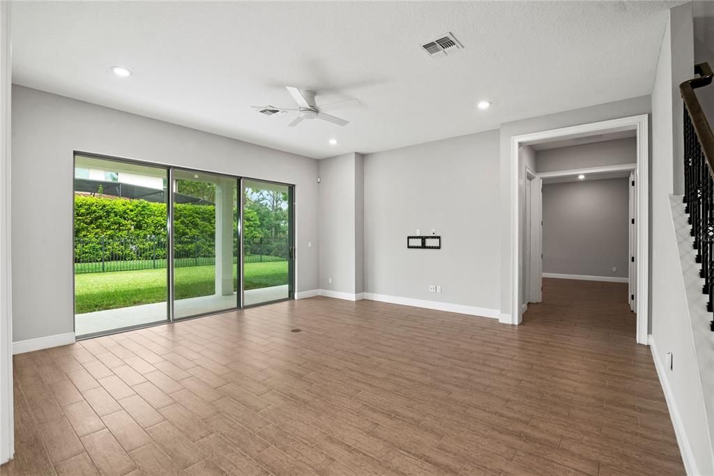 Family Room with oversized slider doors provide view and access to an extended covered lanai and fenced in back yard