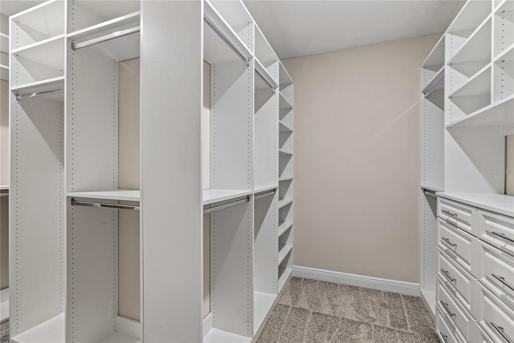Enormous walk in closet with custom shelving and drawers