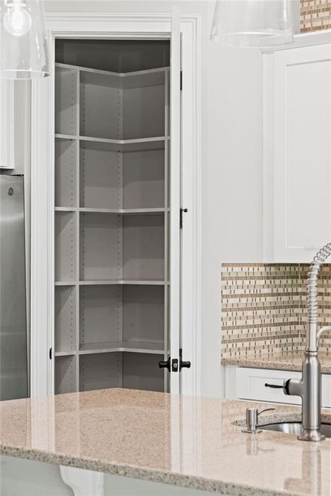Walk in pantry with custom shelving to meet your organizational needs