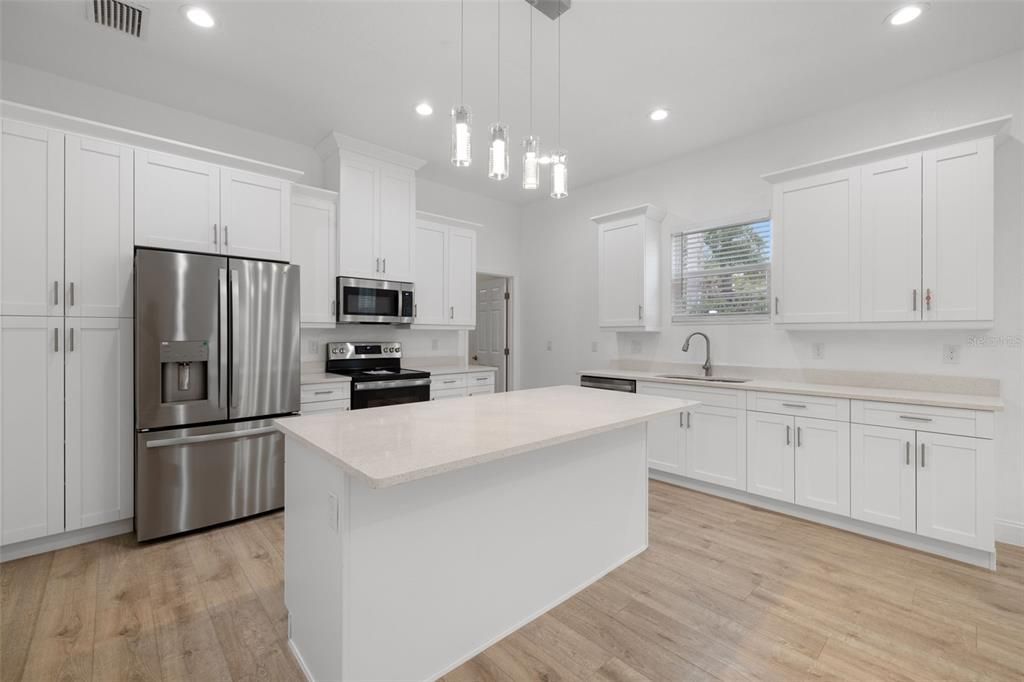 Kitchen with new appliances, pantry, soft close cabinets w sparkling Quartz countertops