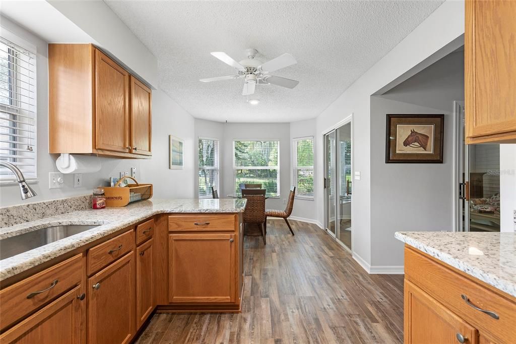 Breakfast nook with bay windows and sliding doors leading out to enclosed lanai.