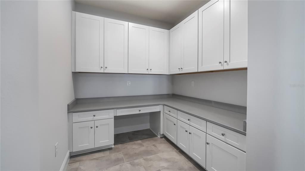 Flex space just off family room with cabinets and quartz countertops.