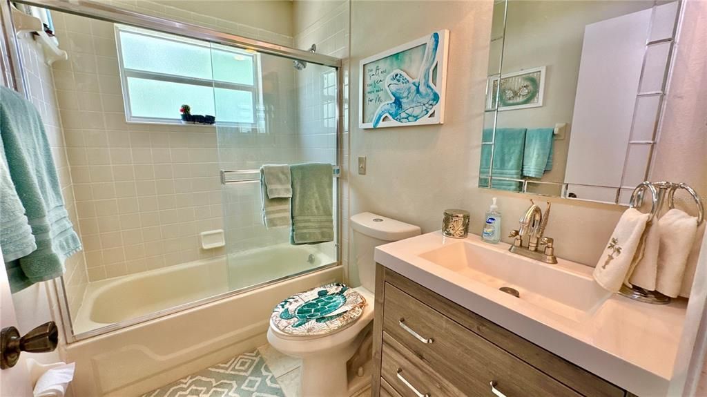 Newer vanity in guest bathroom with tub