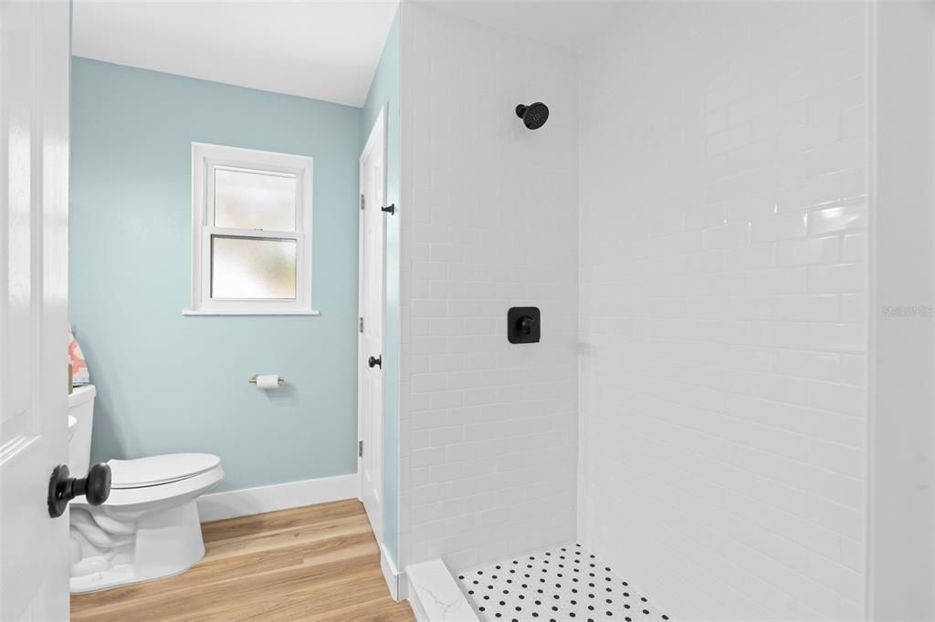 Upstairs shower completely renovated with classic subway tile and matte black fixtures.