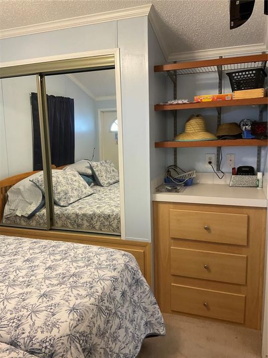 Bedroom with built in dresser and shelving