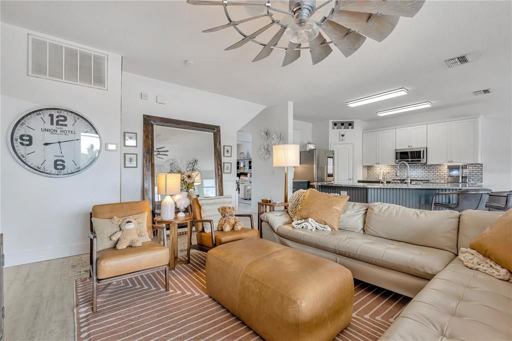 Family room with an exceptional ornate windmill x large fan that creates a great draft of wind a Suttle lighting.  This couch is a lower couch because it keeps your view outside in your home.  Just a thought....
